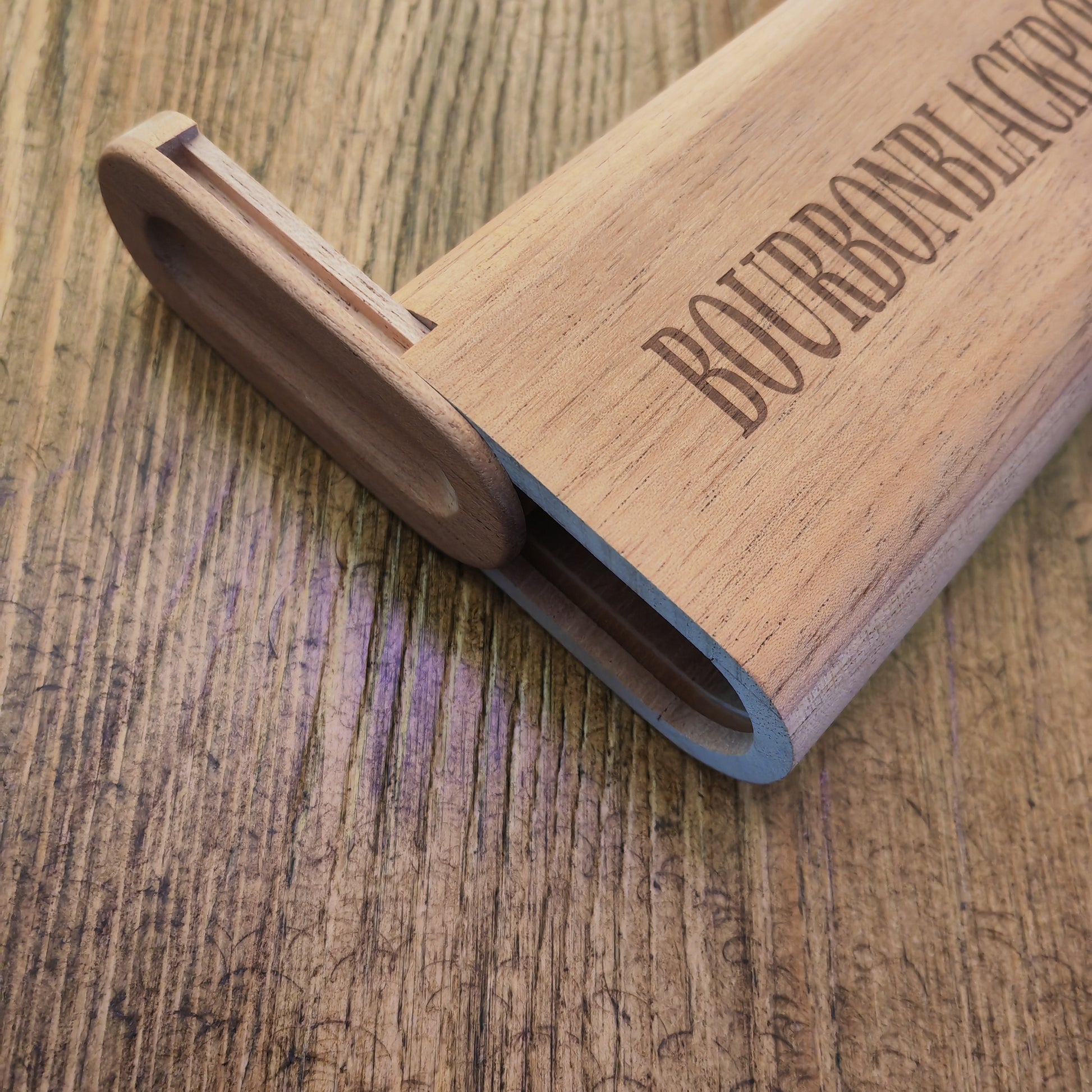 Wooden cigar case with 'Bourbon Black' engraving on a wooden surface