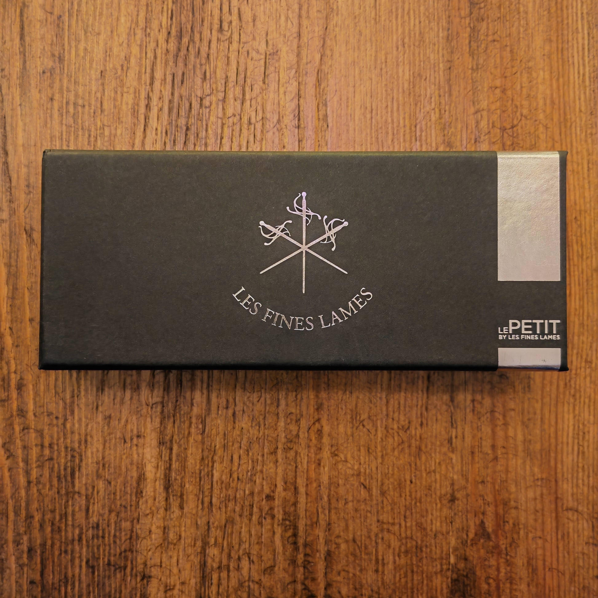 Black box with 'Les Fines Lames' logo on a wooden surface