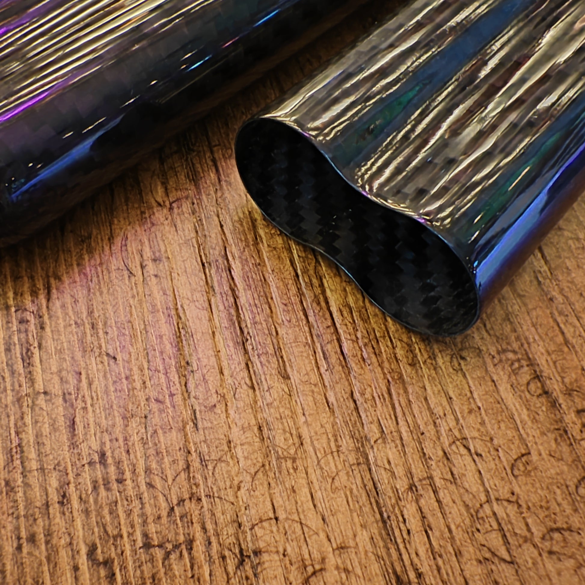 Black carbon fiber cigar case on a reflective metallic surface