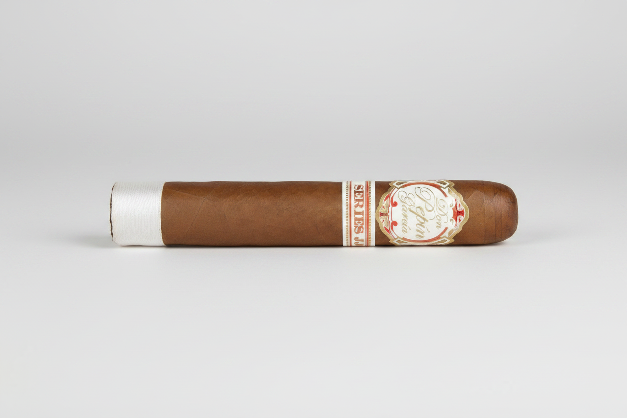 A single brown cigar shown horizontally against a white background, with a white paper band at one end and a decorative gold, red, and white label on the other.