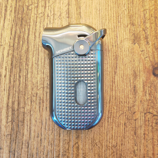 Metallic cigar lighter with textured grip on a wooden surface