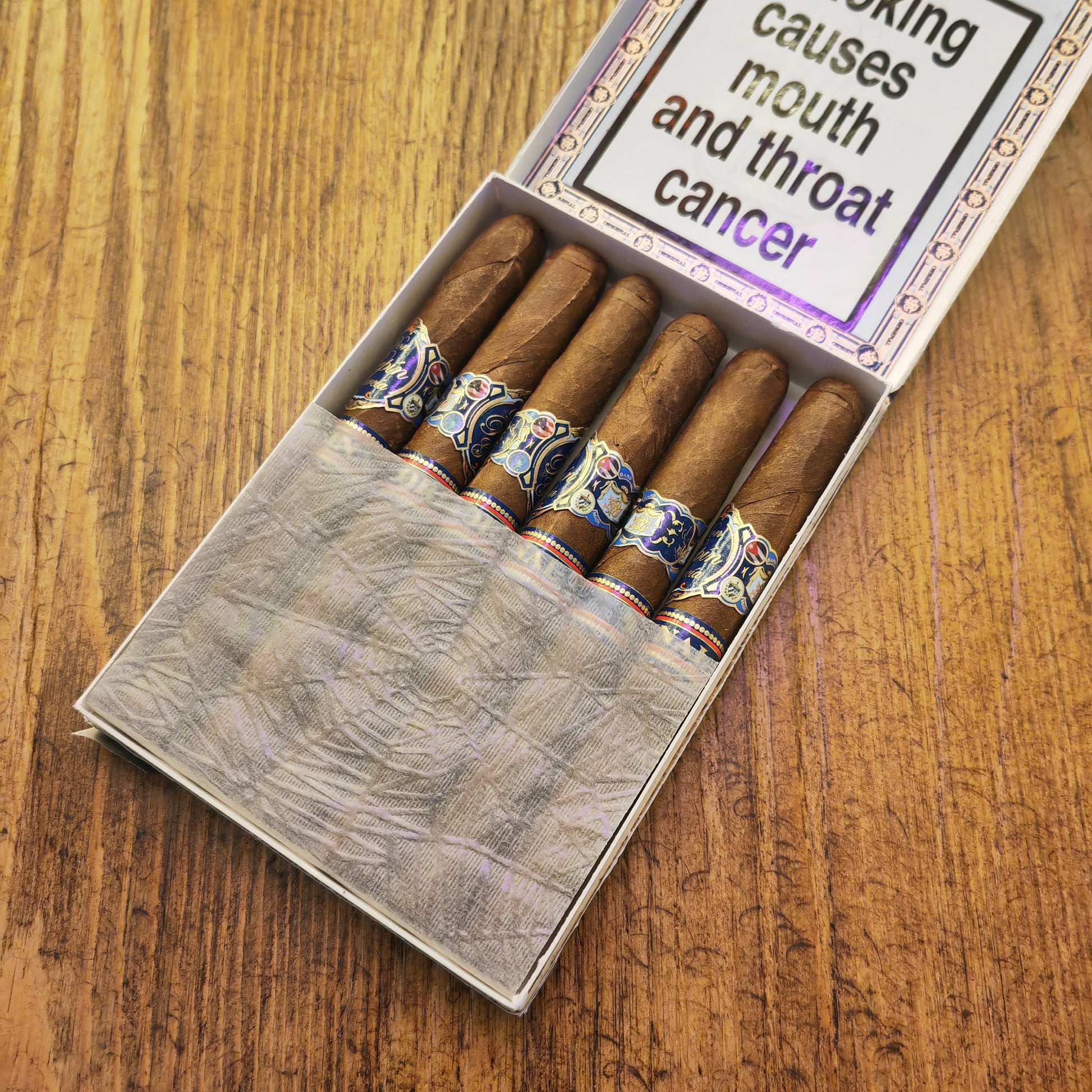 Box of cigars with a warning label on a wooden surface