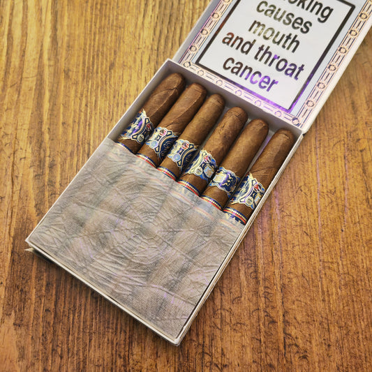 Box of cigars with a warning label on a wooden surface