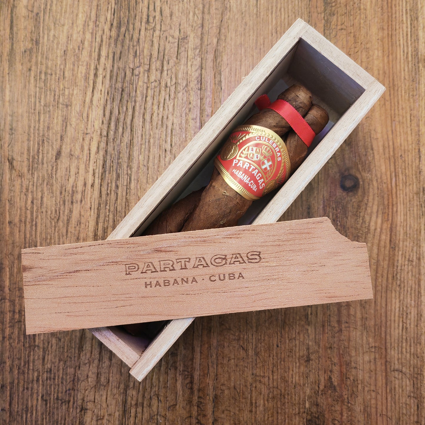 Partagas cigar in a wooden box on a wooden surface