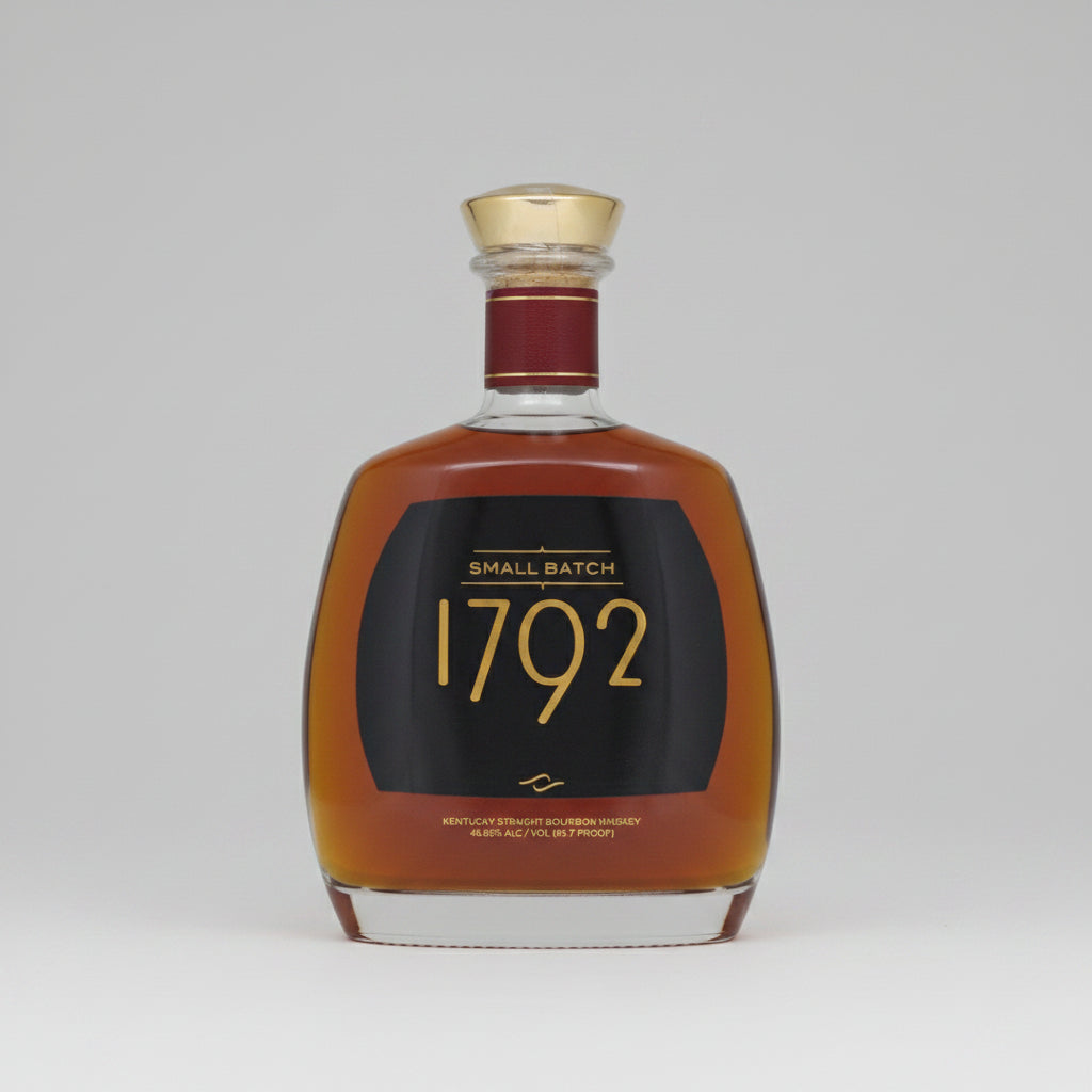 A bottle of 1792 Small Batch Kentucky Straight Bourbon Whiskey with amber liquid, a black label with gold lettering, and a gold cap, isolated on a white background.