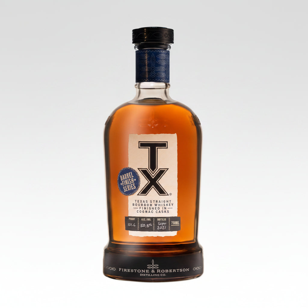 A bottle of Texas Straight Bourbon Whiskey from Firestone & Robertson Distilling Co., featuring a large white 'TX' logo on the front label, amber liquid inside a clear glass bottle, and a dark blue and black cap.