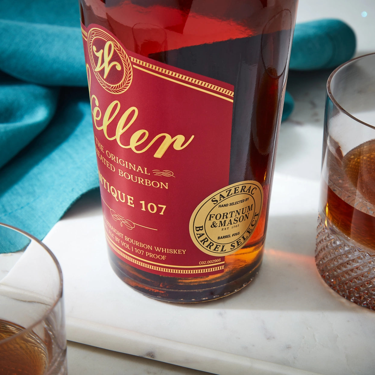 weller bourbon bottle with a glass of whiskey on a marble surface