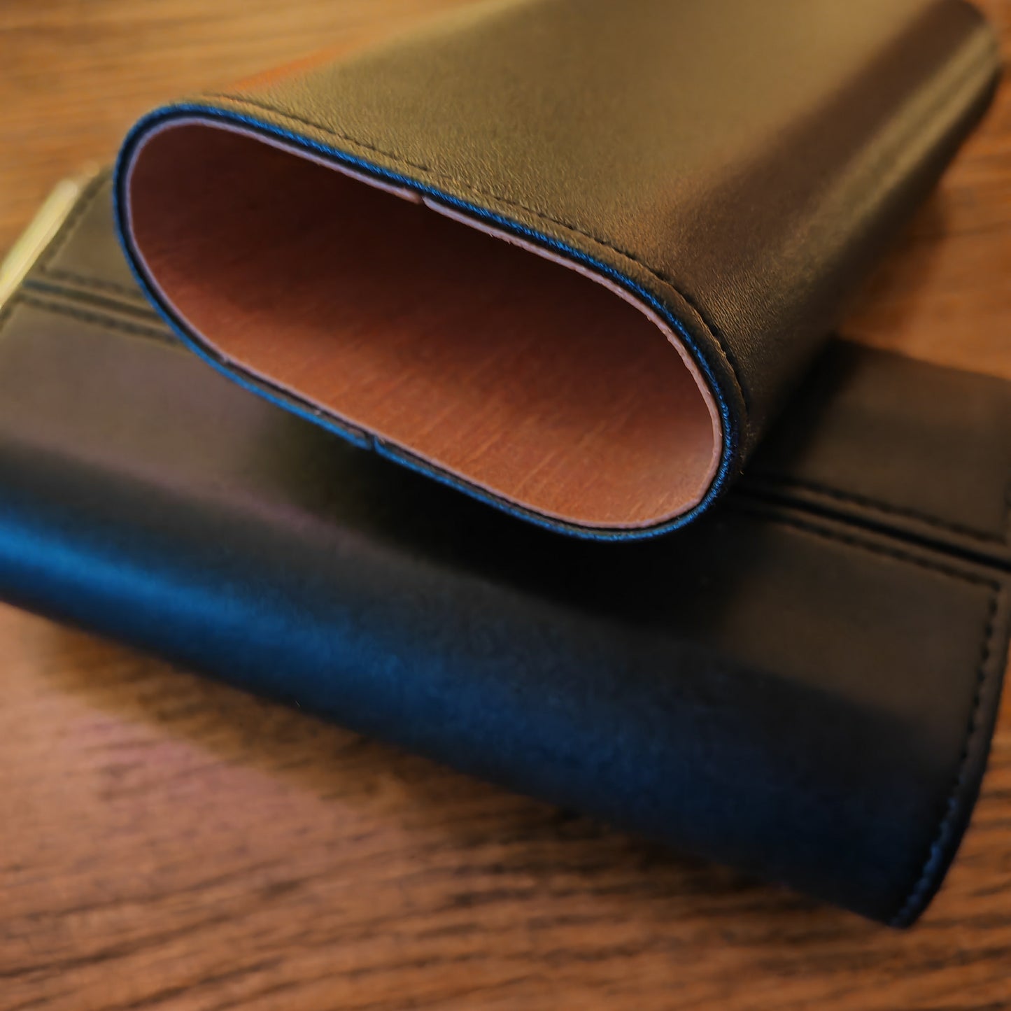 Close-up of ablack leather wallet on a wooden surface with cedar lining