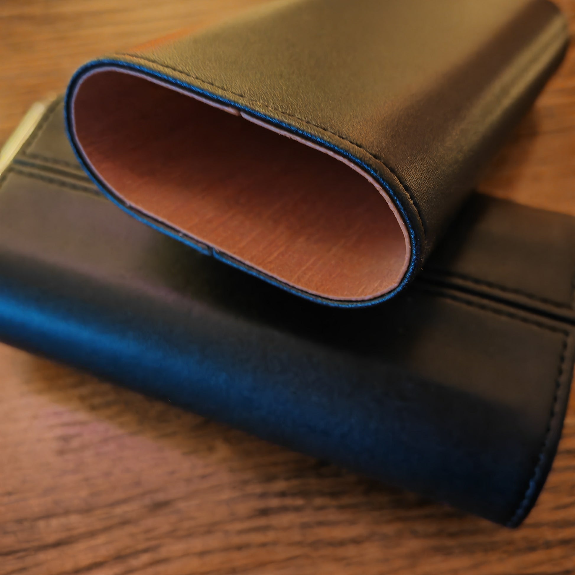 Close-up of ablack leather wallet on a wooden surface with cedar lining