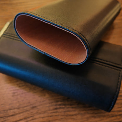 Close-up of ablack leather wallet on a wooden surface with cedar lining