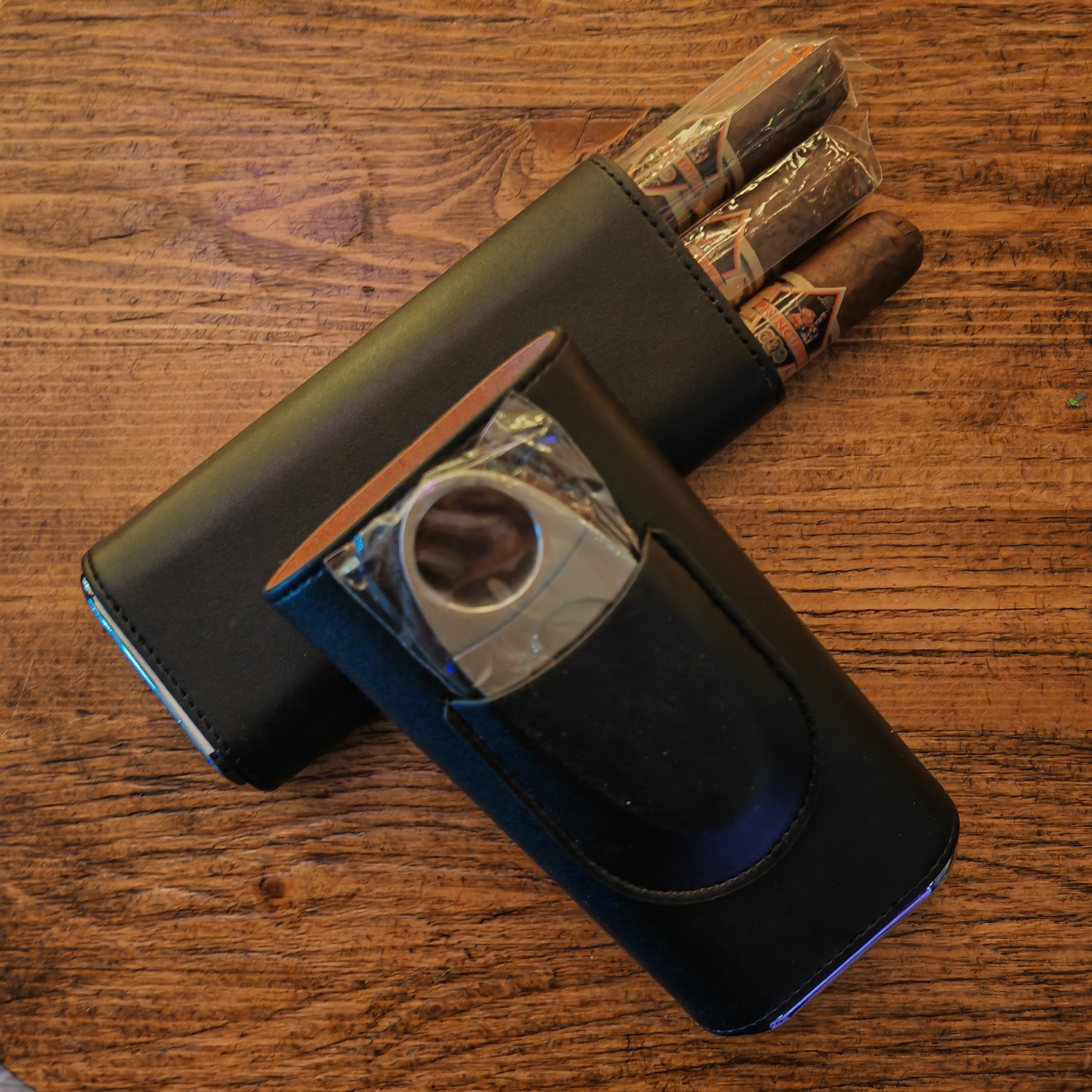 Cigar cutter with cigars on a wooden surface