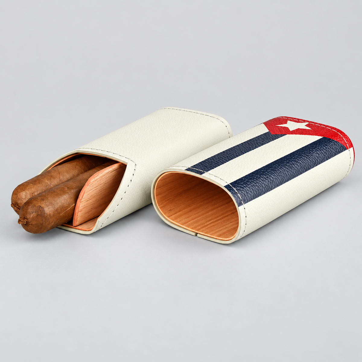 Two leather cigar cases on a light gray background, one open with two cigars inside and one closed showing a Cuban flag design.