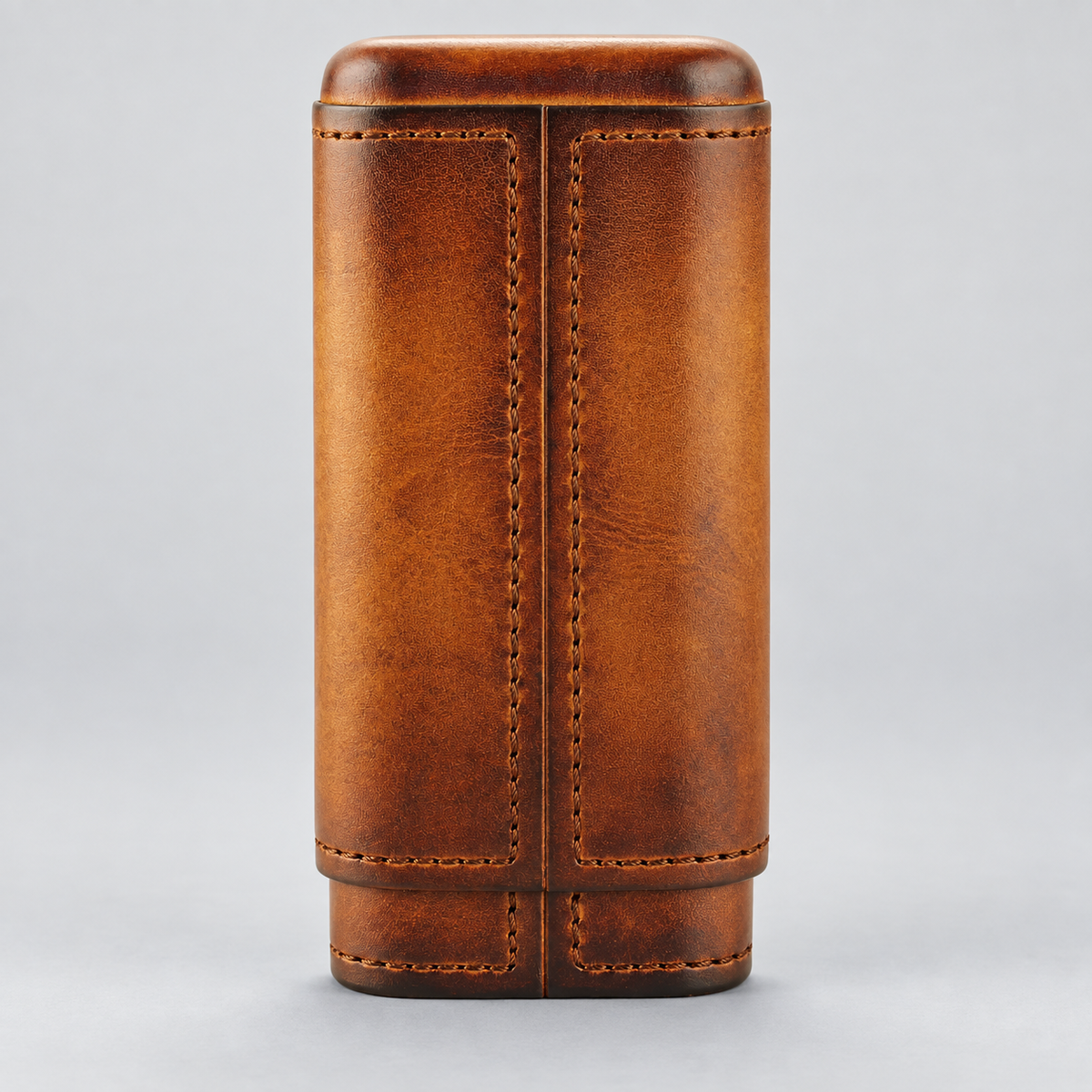 A brown leather cylindrical case with stitched panel detailing, shown upright against a light gray background.
