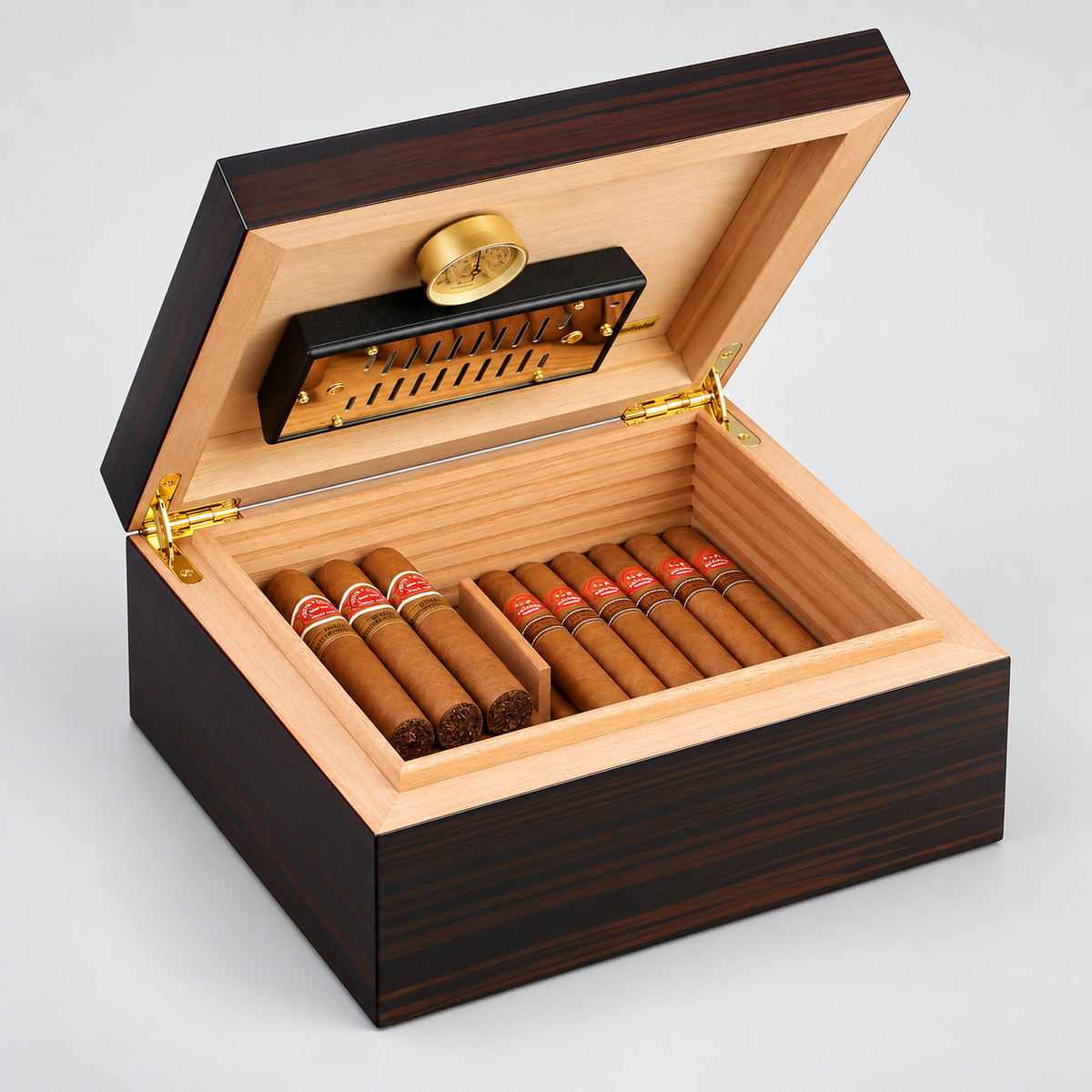 An open premium cigar humidor box made of dark wood grain with a light natural wood interior, containing multiple cigars. The box features a gold hygrometer and humidifier on the inner lid, set against a neutral light gray background.