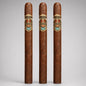 Three tall, slender cigars standing upright against a light gray studio background. Each cigar has a warm medium-brown wrapper and a decorative band near the top featuring the brand name 'Luis Alvarez' and the product name 'Premiado'.