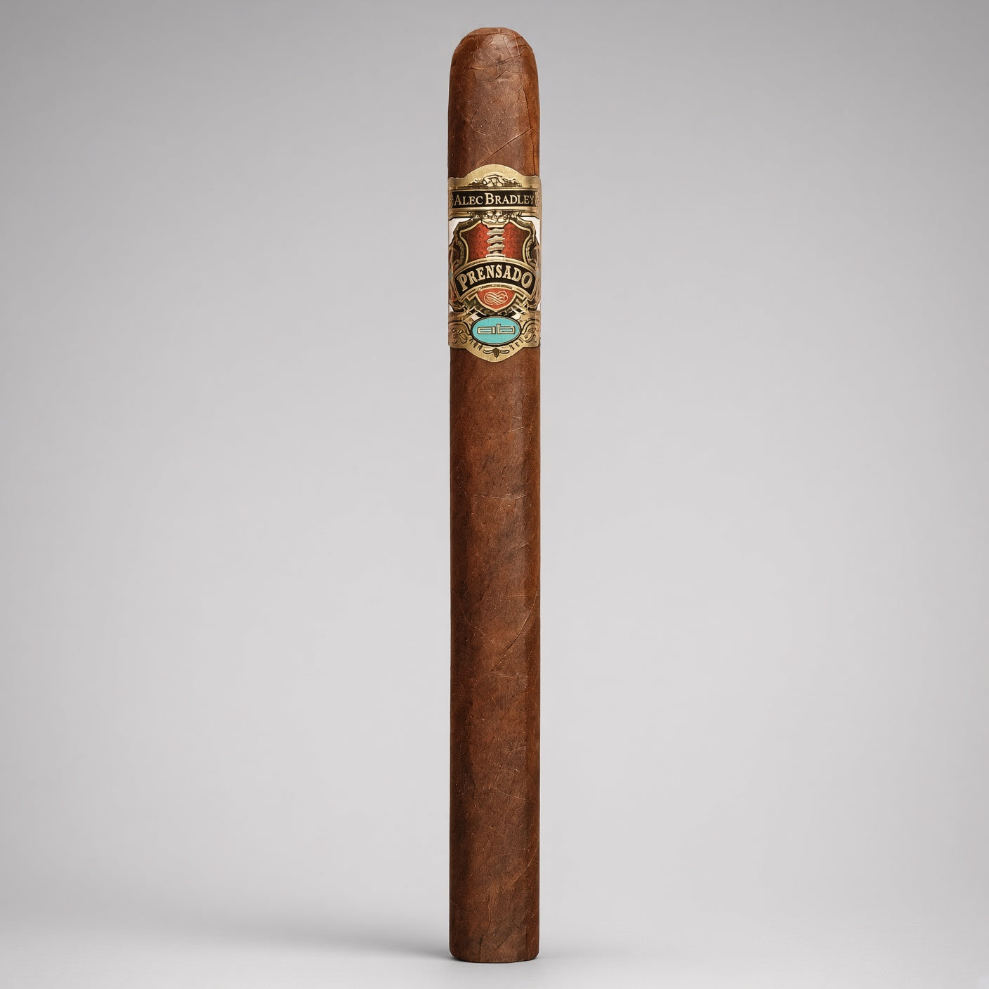 A single premium cigar standing upright against a neutral light gray background. The cigar has a rich medium-brown wrapper with a detailed silver, gold, and turquoise band from the brand Los Altos.