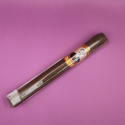 Cigar with a decorative band on a pink background
