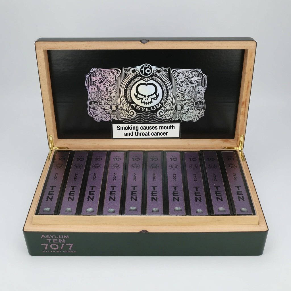 An open wooden box containing multiple purple packets of Asylum Ten Cigars, with a black inner lid featuring a silver skull graphic and a warning label.
