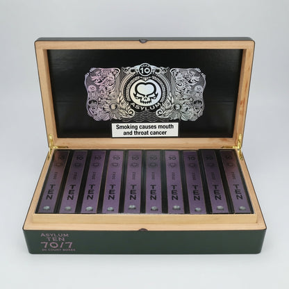 An open wooden box containing multiple purple packets of Asylum Ten Cigars, with a black inner lid featuring a silver skull graphic and a warning label.