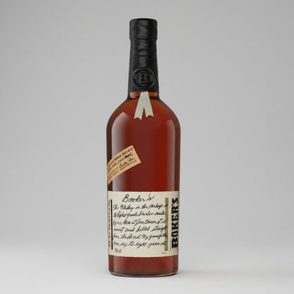 A bottle of Booker's american Whiskey, featuring amber liquid, a black wax-sealed cap with a silver ribbon, and cream-colored labels with black text.