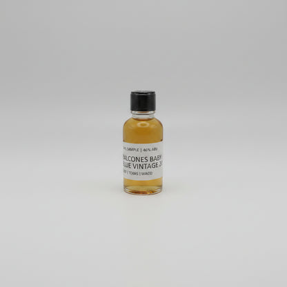 Small bottle of Balcones baby blue with a black cap and white label on a white background