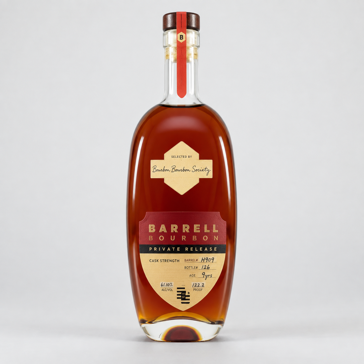 A bottle of Barrel Bourbon Private Release cognac whiskey, featuring a clear glass bottle filled with amber liquid, a cream and red label, and a dark brown cap, set against a light gray background.