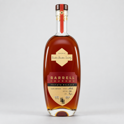 A bottle of Barrel Bourbon Private Release cognac whiskey, featuring a clear glass bottle filled with amber liquid, a cream and red label, and a dark brown cap, set against a light gray background.