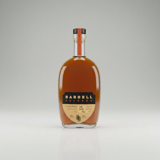 A bottle of Barrel Gold Whiskey with a small filled whiskey glass on a light beige surface.