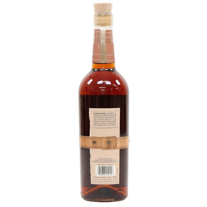 Bottle of whiskey with a cork stopper on a white background