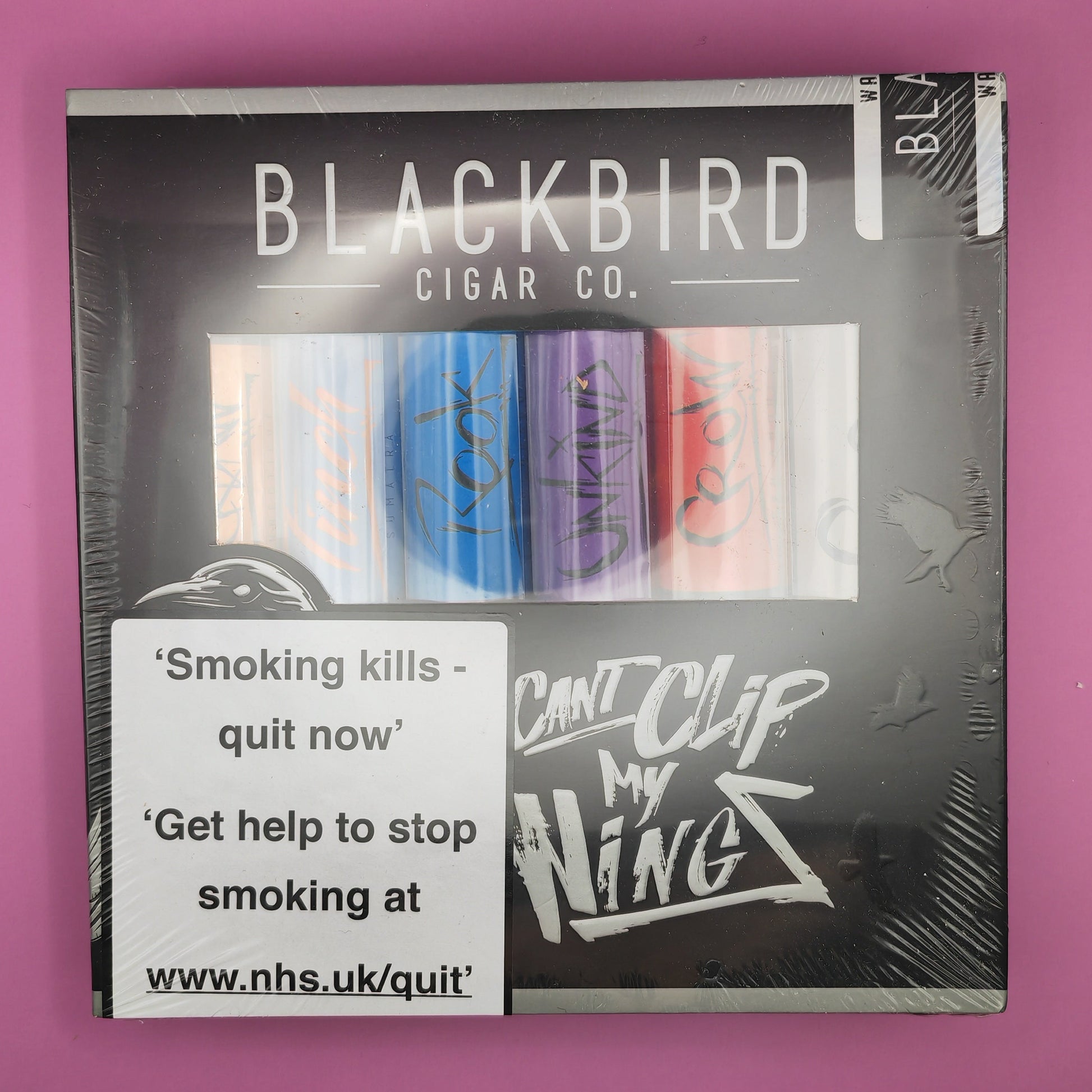 Pack of Blackbird Cigar Co cigars with warning label on a pink background