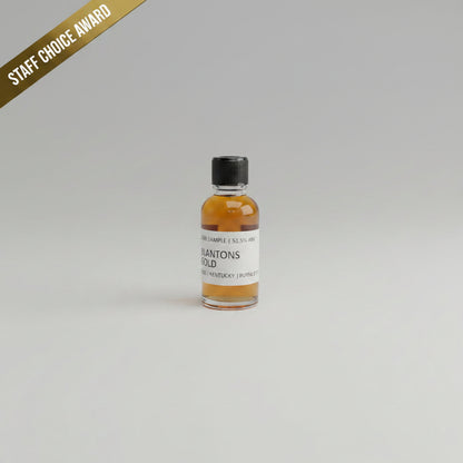 Small bottle of Blanton's Gold bourbon on a beige background