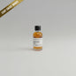 Small bottle of Blanton's Gold bourbon on a beige background