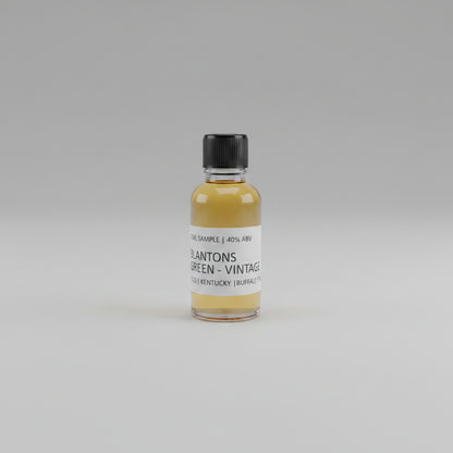 Small bottle of Blanton's Green Vintage whiskey sample on a beige background