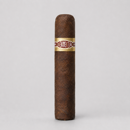 A single brown cigar standing upright against a light gray background, featuring a gold band with red and white lettering that reads 'J. A.