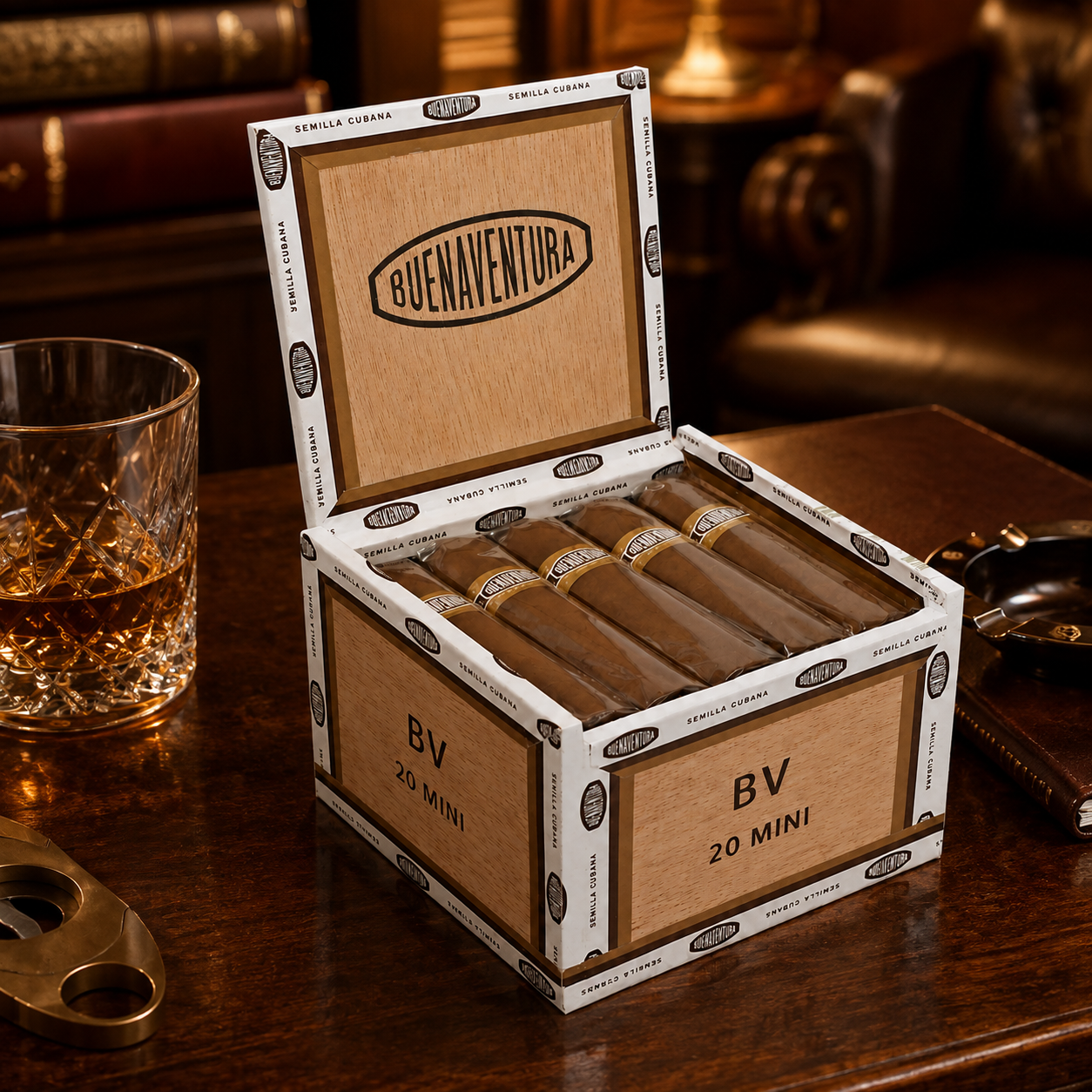 An open cigar box labeled Buena Ventura on a dark wooden table, with several cigars inside and a glass of amber liquid beside it in a warm, upscale setting.