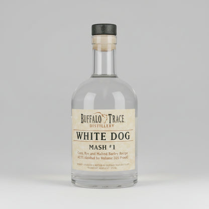 A clear glass bottle of Buffalo Trace Distillery White Dog Mash #1 spirit with a beige label and a black cap, shown against a plain white background.