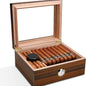Wooden humidor with glass top containing cigars and a humidifier on a white background