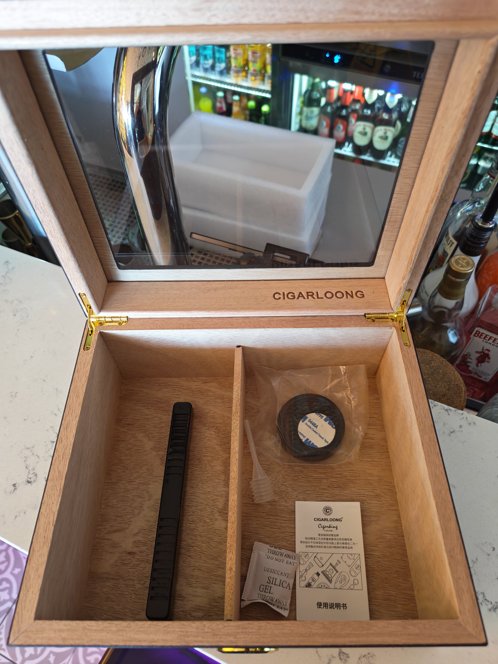 Wooden cigar humidor with accessories on a table