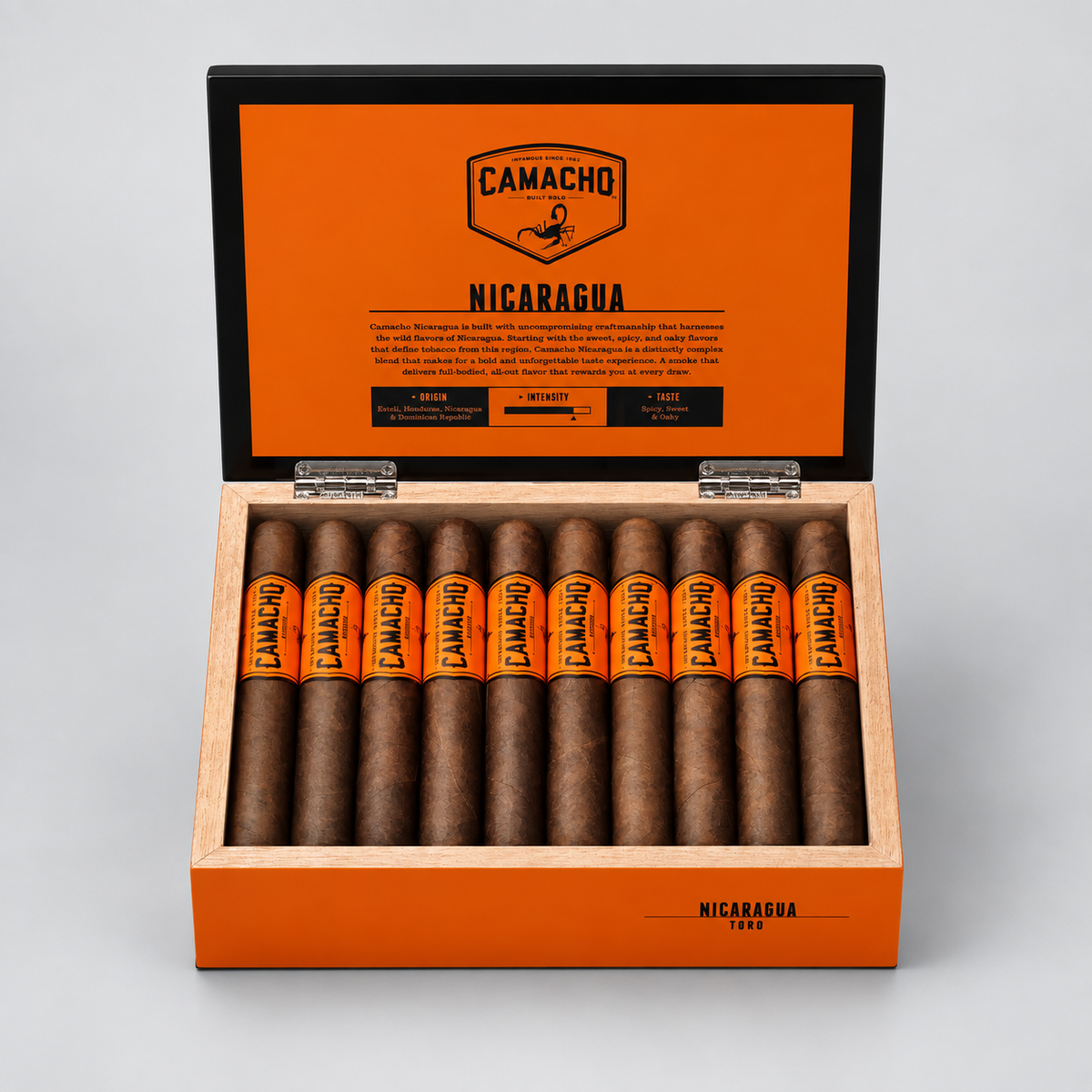 An open Camacho cigar box displaying ten cigars inside, with a bright orange interior lid and a light wood exterior on a neutral gray background.