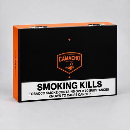 Camacho cigar packaging box in black and orange with a prominent white warning label reading 'SMOKING KILLS' and health text, photographed on a light gray background.