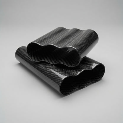 Two rolled sheets of glossy black carbon fiber wrap with a wavy pattern, displayed on a neutral light gray background.
