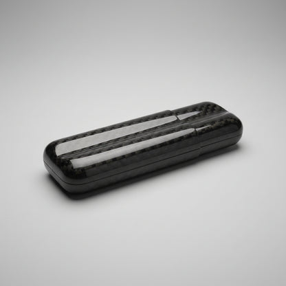 Carbon fiber cigar case with reflective surface on a wooden surface
