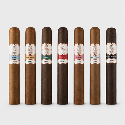 Seven natural cigar humors from The Artisan of Turin are lined up vertically against a light gray background. Each cigar is labeled with its corresponding flavor profile, ranging from Cusco to Double Macchiato, and all feature the year 1880 on the bands.
