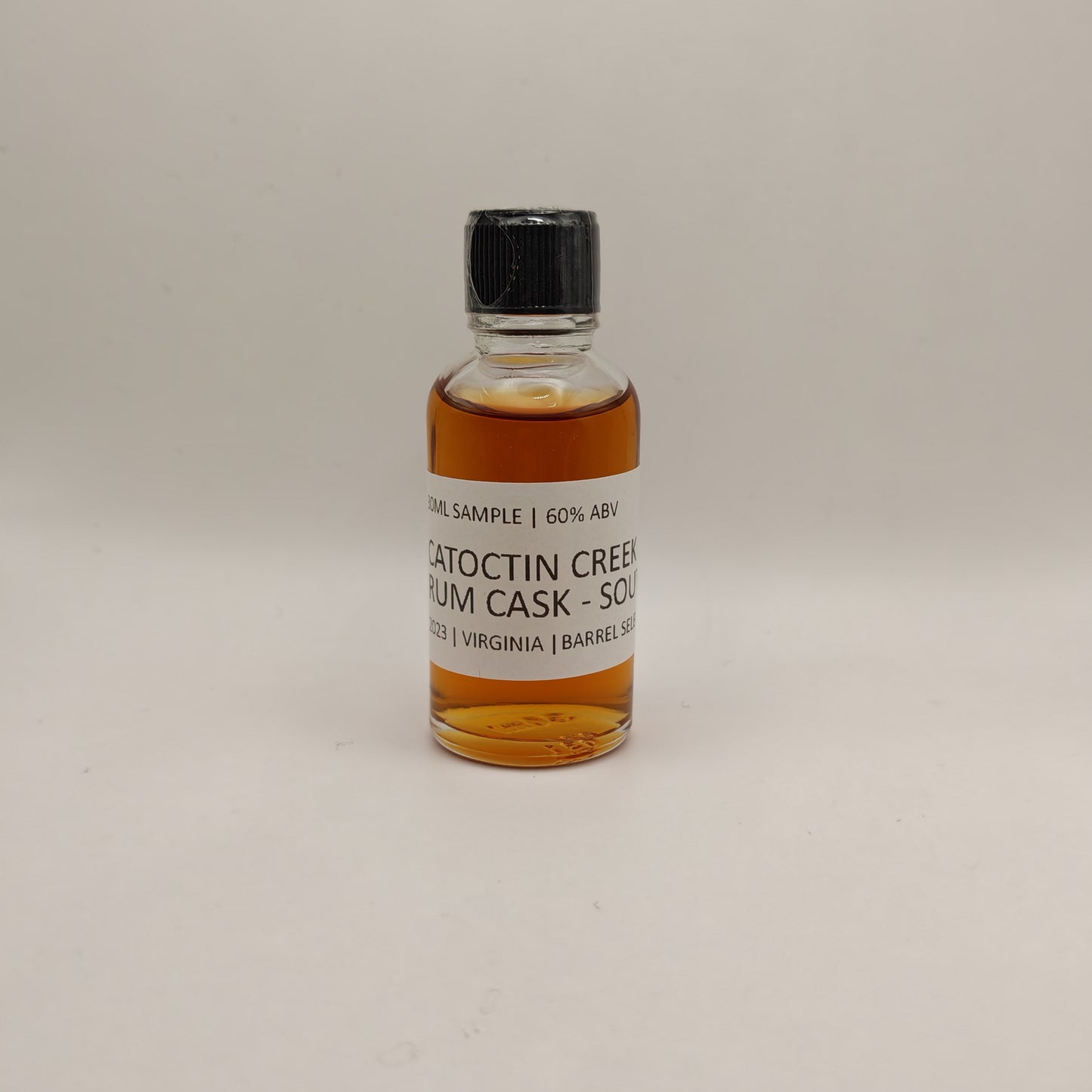 Small bottle of Catoctin Creek Rum cask whiskey with a label on a light gray background