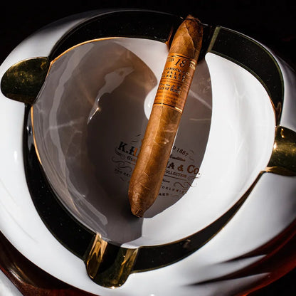 Cigars in a humidor with a lighter on a dark surface