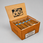An open wooden humidor cigar box containing six wrapped cigars with blue bands, photographed on a light gray studio background. The box has a black printed illustration of a cigar maker on the lid and a smoking warning label on the front.