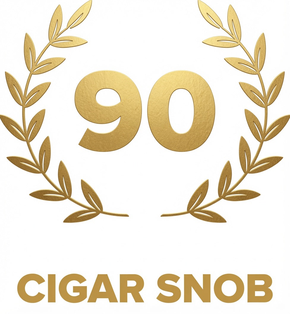 A gold graphic featuring the number 90 centered within a laurel wreath, with the text 'CIGAR SNOB' below in gold on a white background.