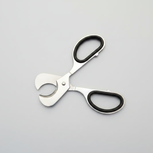 A pair of stainless steel cigar sisssors in a studio background