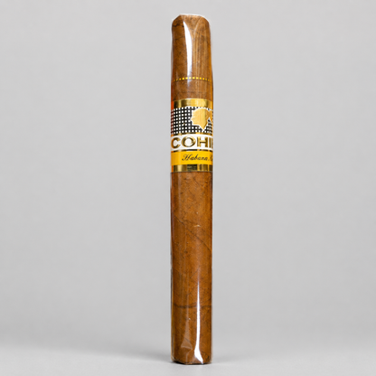 A single Cohine Habanero cigar, still sealed in its clear plastic wrapper, standing vertically against a neutral light gray background. The cigar features a golden band with the Cohine brand logo and the word 'Habanero'.