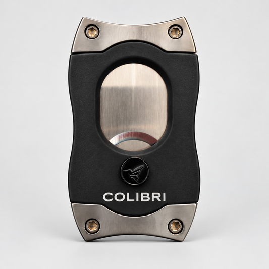 A black and silver COLIBRI cigar cutter with a brushed metal circular window and textured black body, centered on a light gray background.